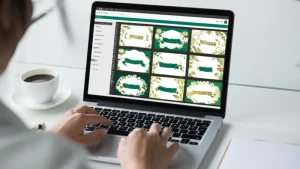 Desainer membuat border undangan digital PNG di laptop dengan motif batik dan bunga