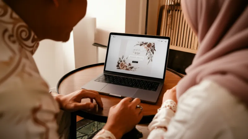Jasa undangan digital berbasis website - pasangan Indonesia melihat undangan digital di laptop